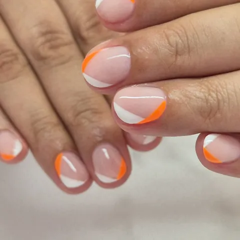 Uñas cortas en nude con diagonales en blanco y naranja neón