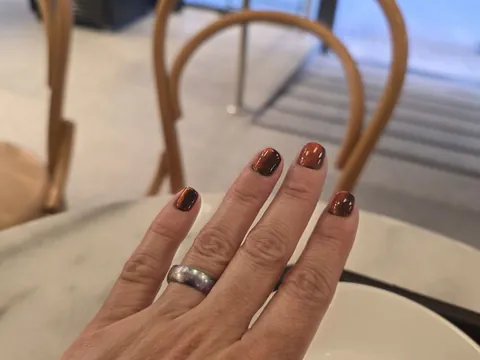 Uñas cortas con efecto ojo de gato en cobre
